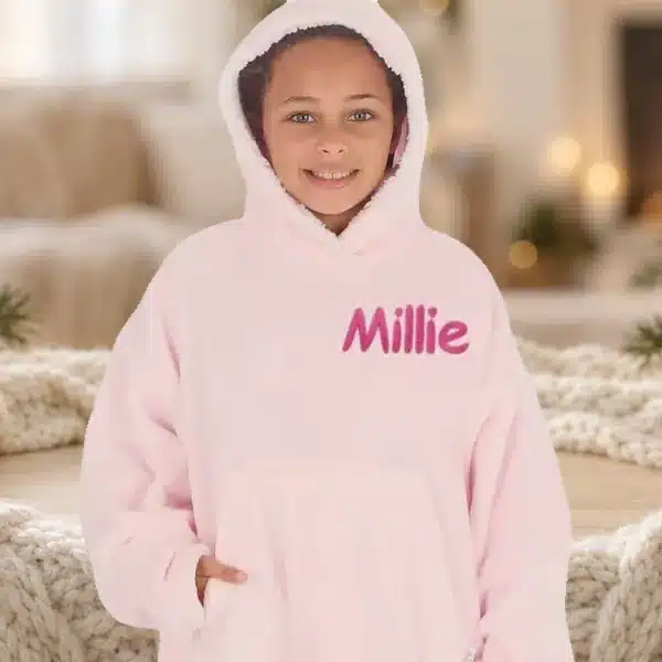 Girl in a pink personalised oversized hoodie embroidered with Millie