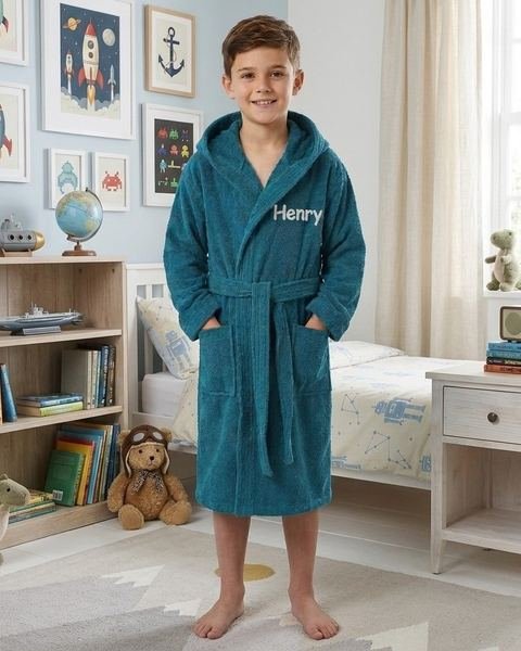 Boy in a teal personalised kids towelling robe embroidered with his name